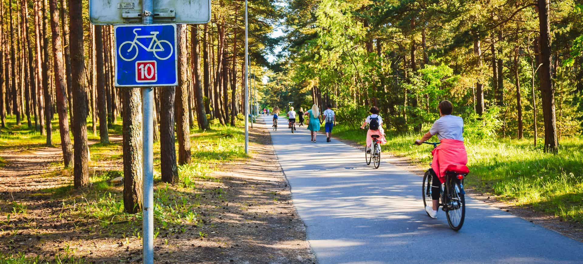 Cyclistes à vélo sur la route Eurovelo 10 dans la forêt de pins pittoresques à Palanga resort, Lituanie Cyclistes à vélo sur la route eurovelo dix dans la forêt de pins pittoresques à Palanga resort, Lituanie